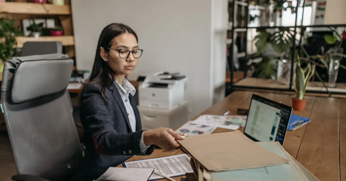 Business license vs LLC: Woman reviewing LLC formation documents for her OnlyFans business.