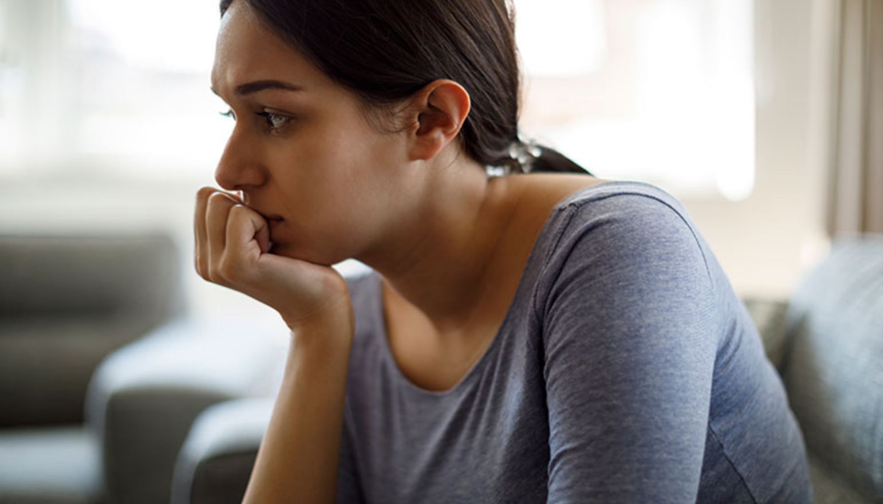 Ettertenksom kvinne i sofa – refleksjon rundt behandling og mestring.