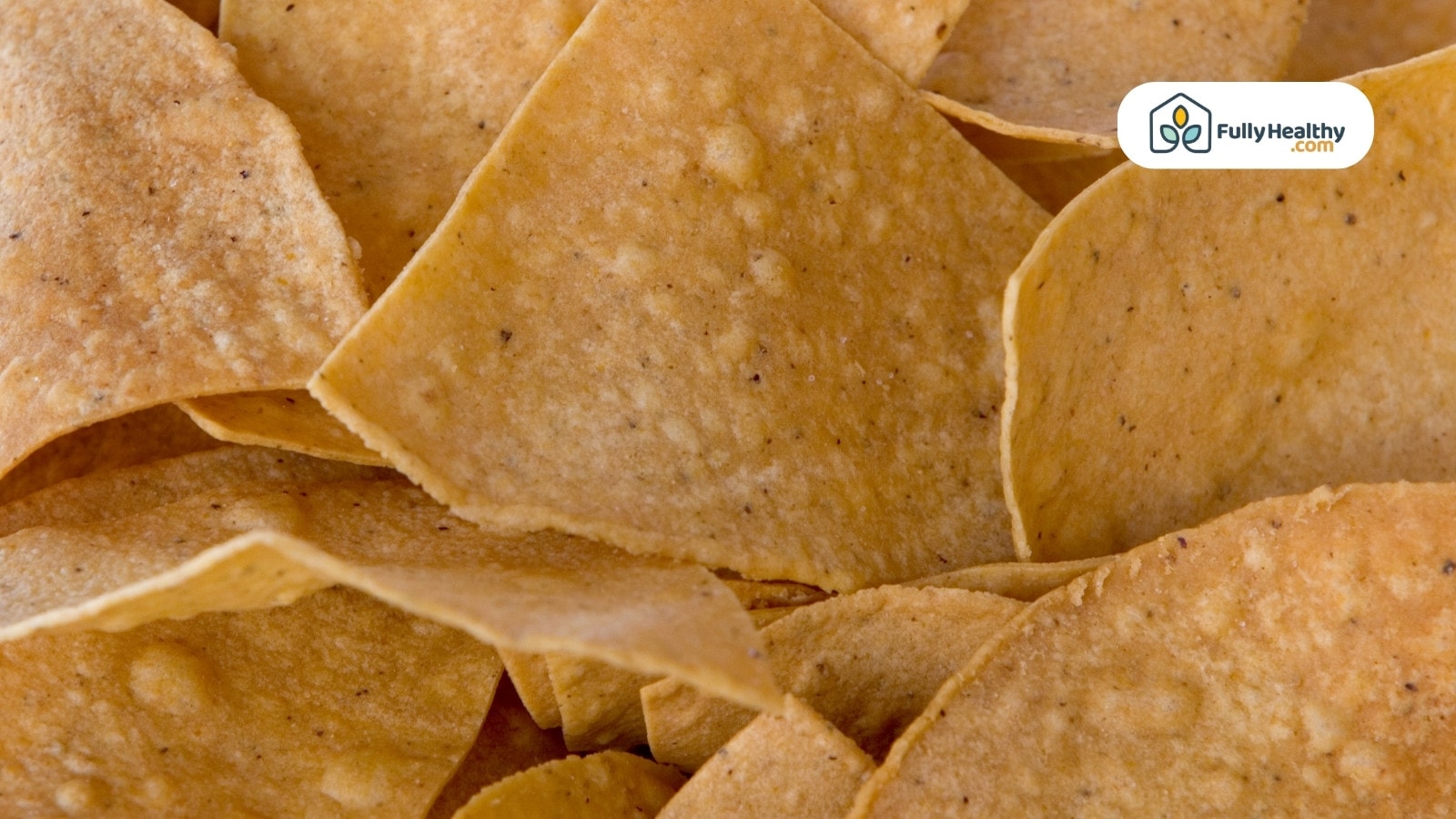 Close-up of crispy tortilla chips on a wooden surface.