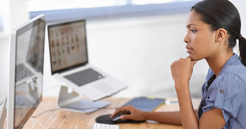 A woman at her computer, representing the importance of perspective in navigating modern work and complexity.