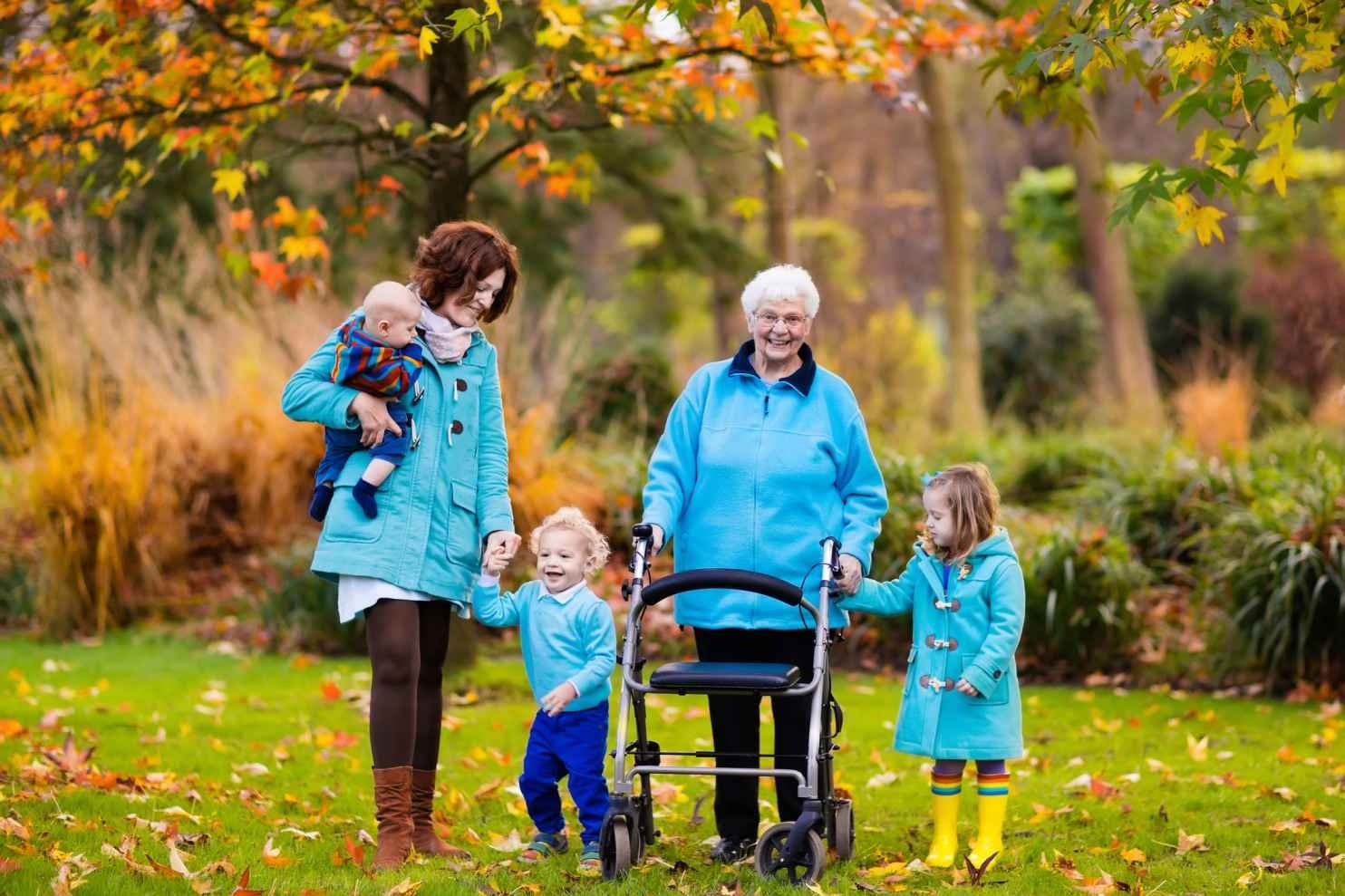 Happy grandmother using a rollator walker in the park with her family – example of rollator functionality for active senior lifestyles.