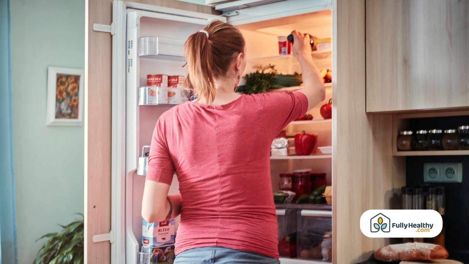 Woman organizing food items in a refrigerator at home