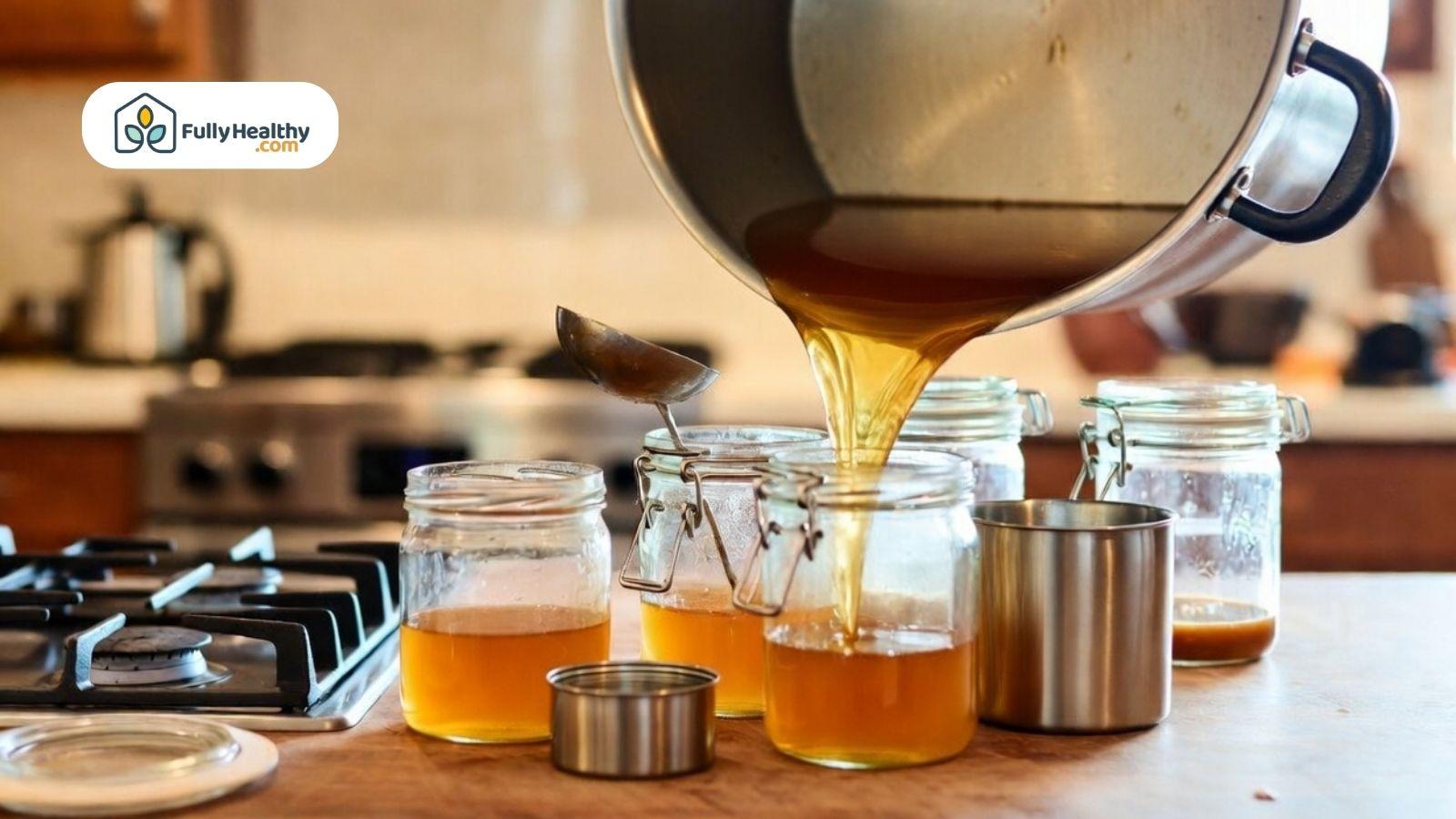 Freshly made broth being poured into glass jars for storage.