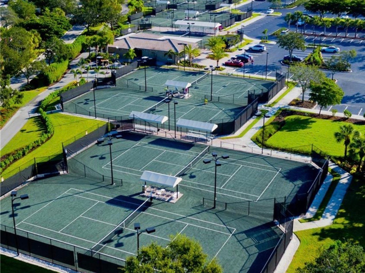 An aerial view showcases the championship golf courses of Shadow Wood, surrounded by luxurious homes and lush natural preserves, highlighting the beauty of the Brooks community in Southwest Florida. The tranquil setting emphasizes the resort-style amenities and the desirable neighborhoods that define this prestigious area.