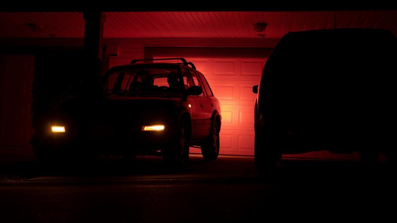 Car with light shining off garage door