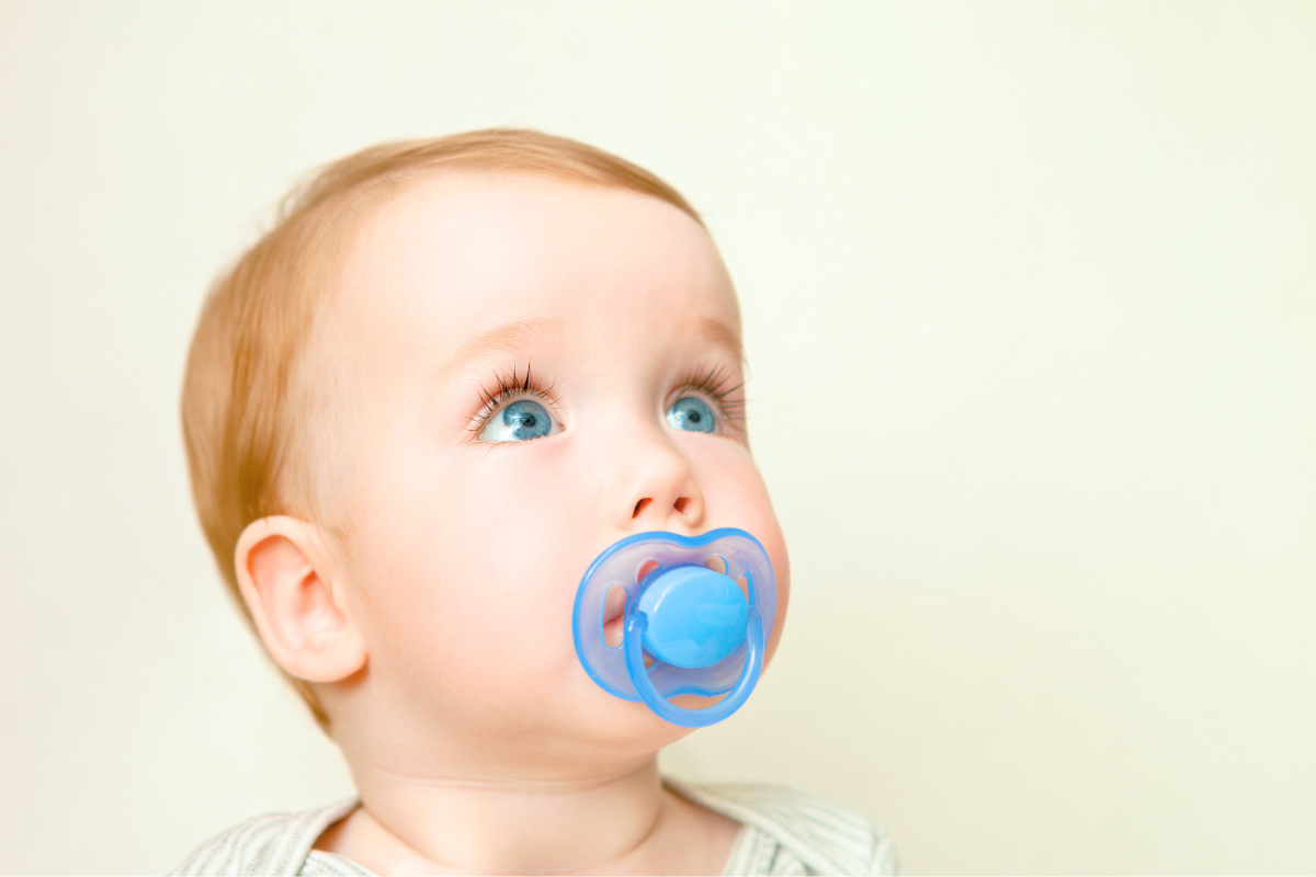 Baby with binkie and pacifier in mouth