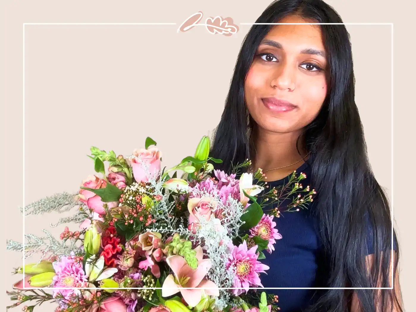 A woman with long black hair, wearing a navy top, holding a vibrant bouquet of pink and green flowers, smiling softly.