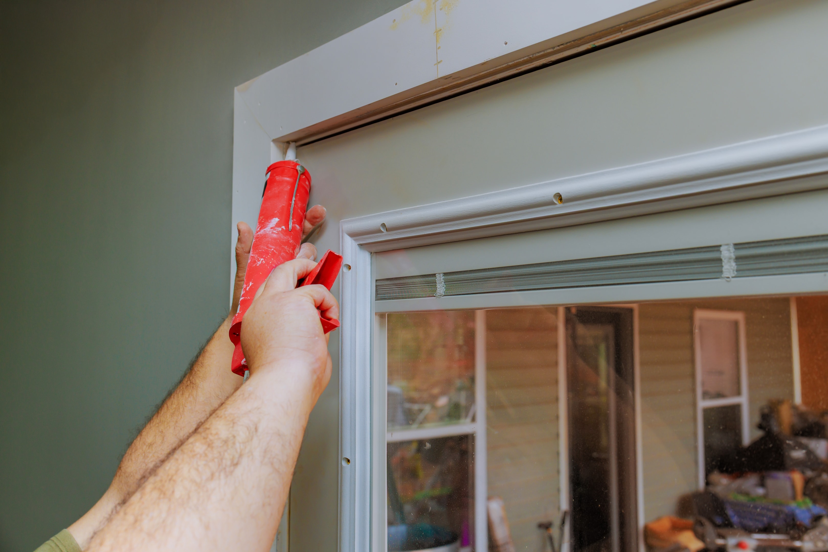 Installing weatherstripping to soundproof a door.