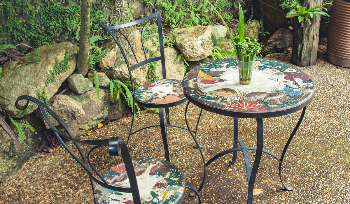 Elegant metal patio furniture - painted detail on seats and tabletop - summer garden 