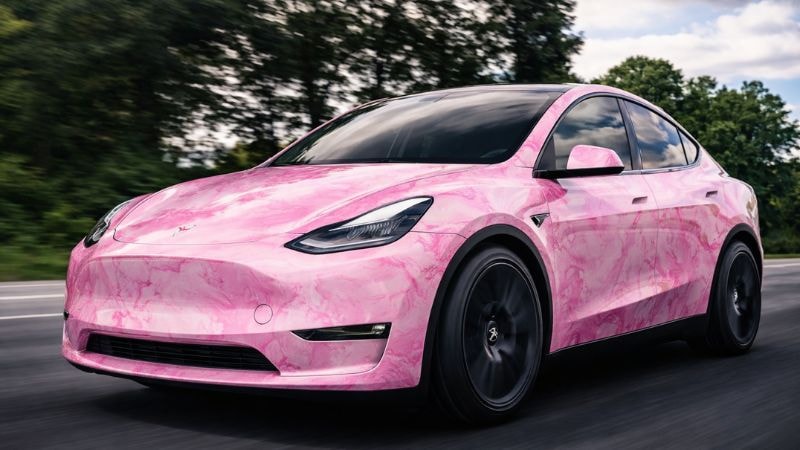 A car on road wrapped in pink colored marble wrap