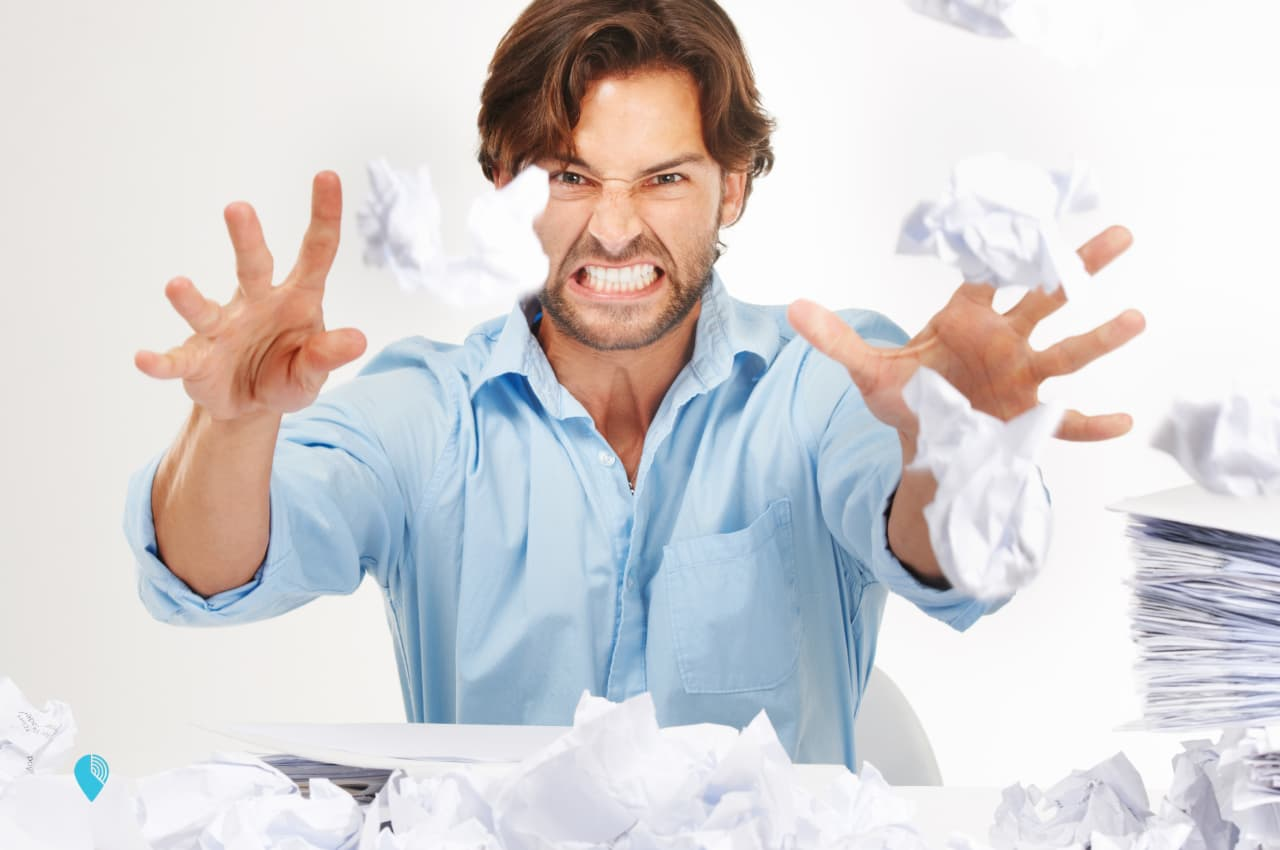 a frustrated payroll admin with stacks of handwritten timesheets