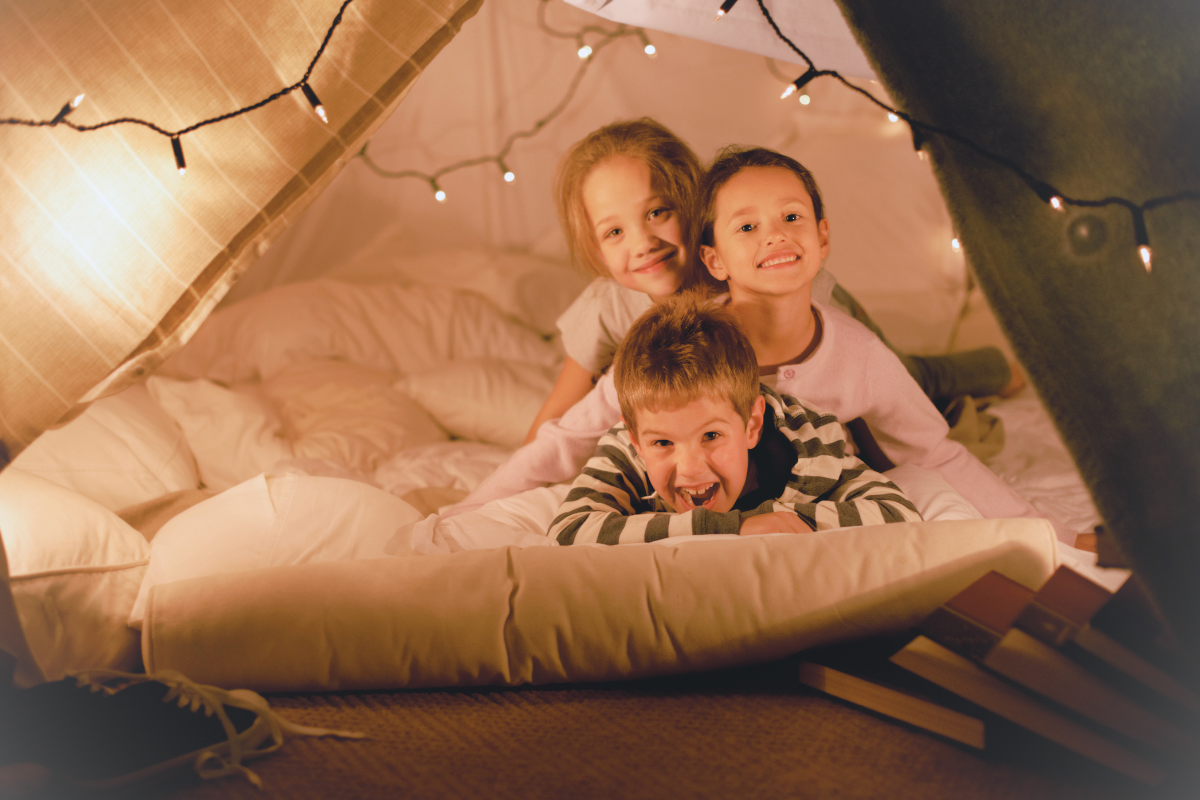 3 children inside a blanket fort