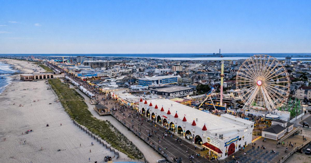 Aerial view of the Ocean City, New Jersey boardwalk and amusement rides along the beach at sunset in America’s Greatest Family Resort on the Jersey Shore.