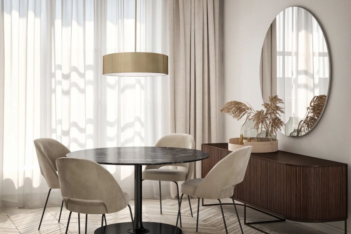 Pendant lights hang from the ceiling above a dining room table, blending modern décor with classic style and balanced length.