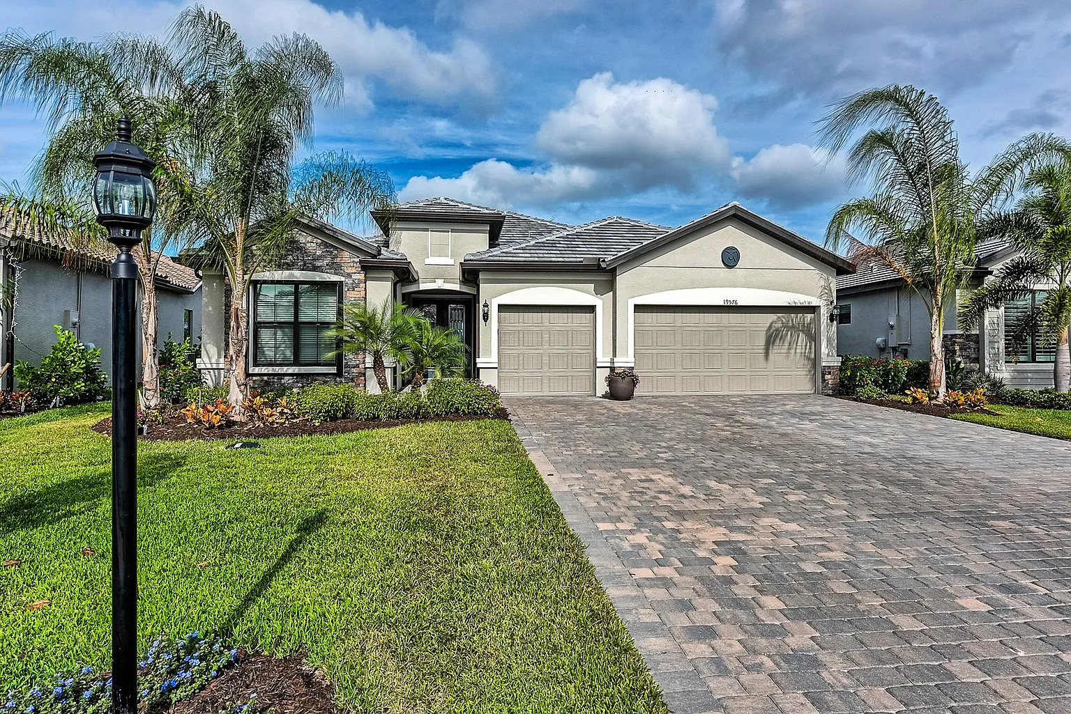 An aerial view showcases Corkscrew Road and the surrounding landscape of Estero, Florida, highlighting the master-planned community of Place at Corkscrew, which features resort-style amenities such as a pool, fitness center, and tennis courts, perfect for family lifestyle and activities. The image captures the vibrant community atmosphere and the scenic beauty of southwest Florida, inviting potential buyers to explore homes for sale in this desirable location.