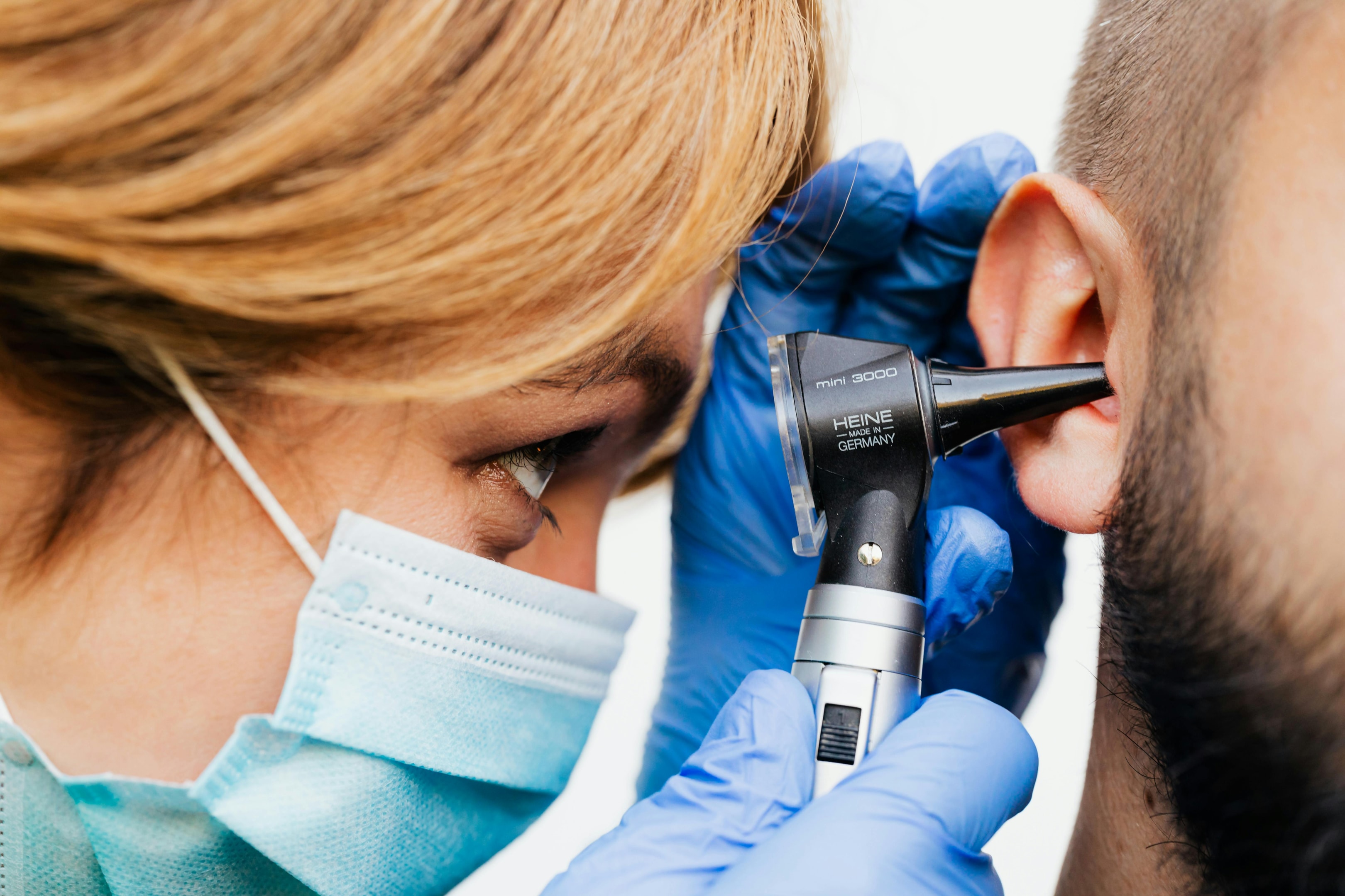 Ear doctor checking patient's ear during a hearing exam