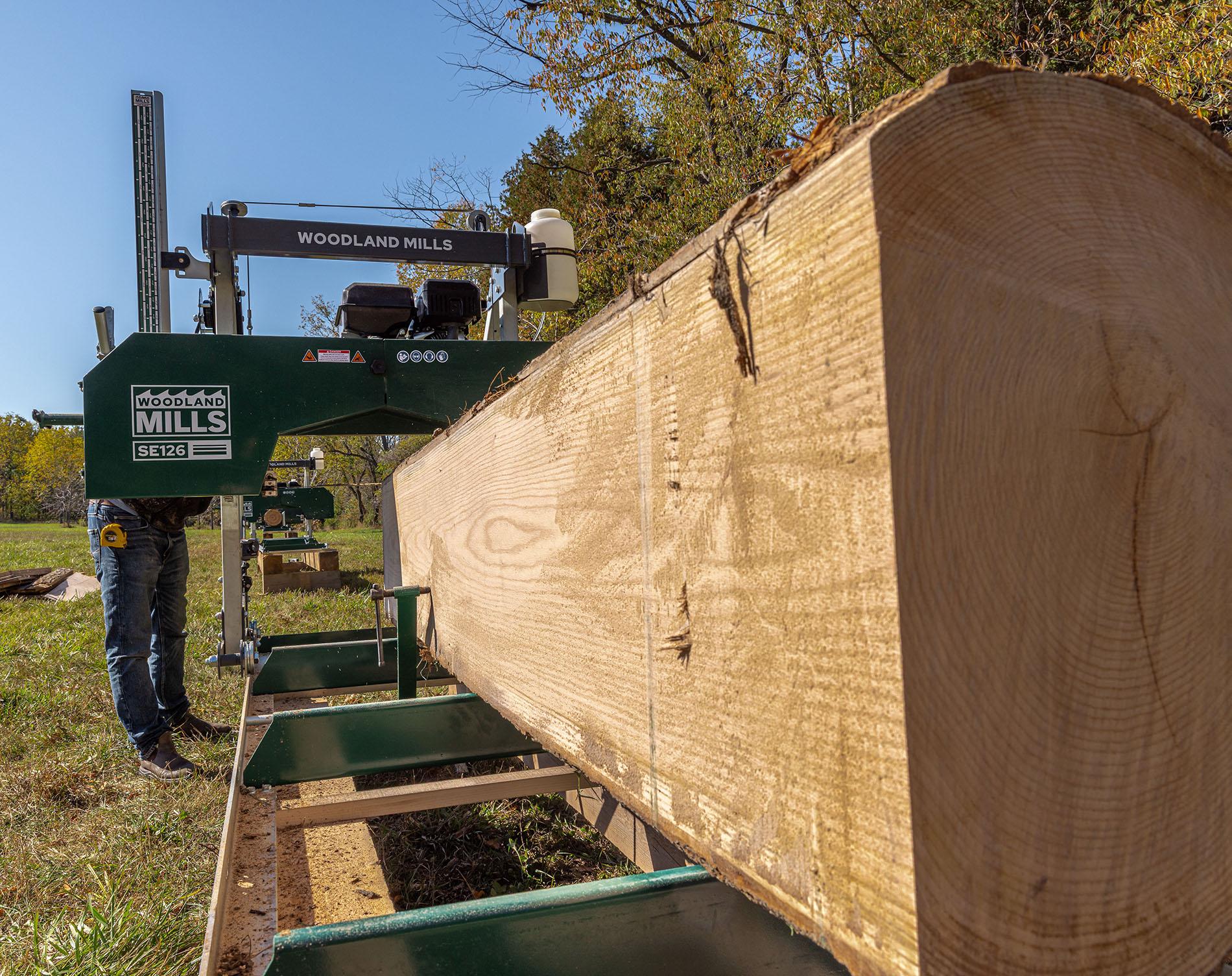 A Woodland Mills SE126 Portable Sawmill cutting up a log into a cant.