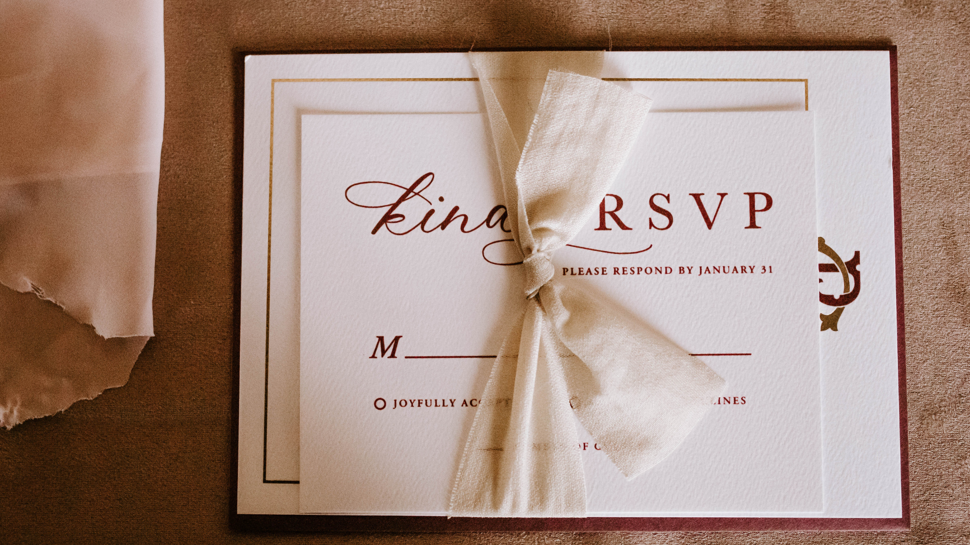 wedding invite with RSVP on tied in a bow