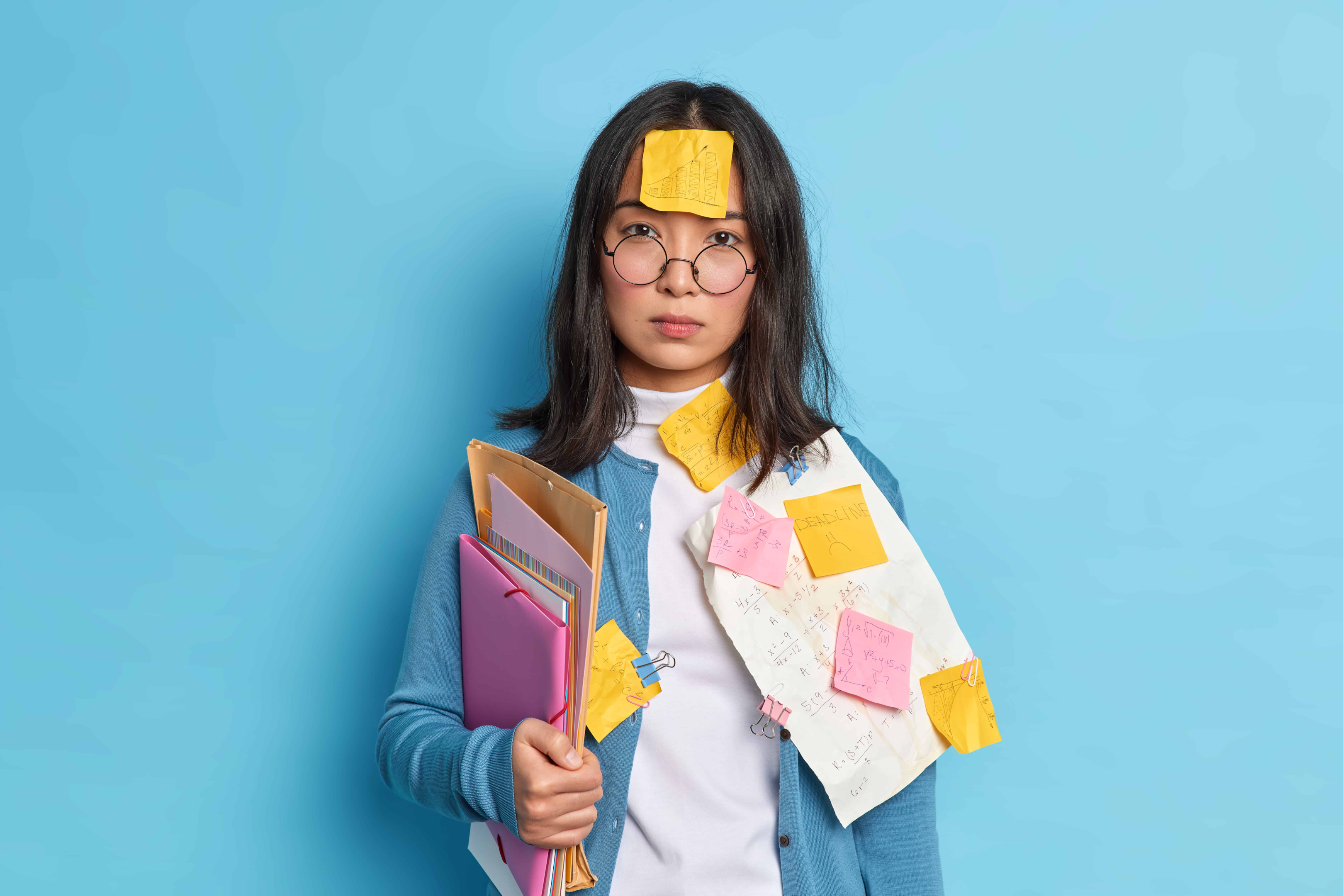A woman with a bunch of papers on her head looking exhausted.