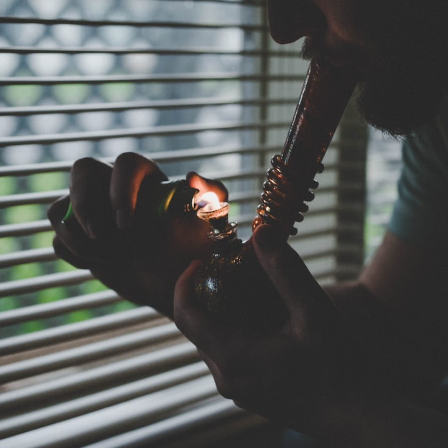 a man smoking from a bubbler bong