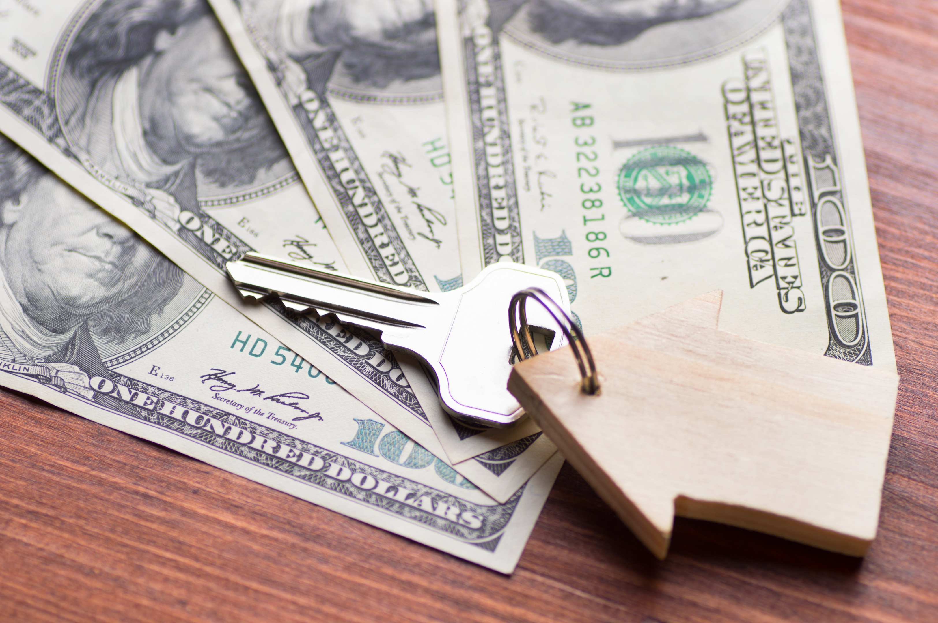 a house key on top of money symbolizing escrow account