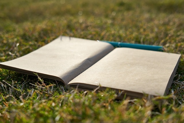 A blank notebook and pen showcasing writing poetry.