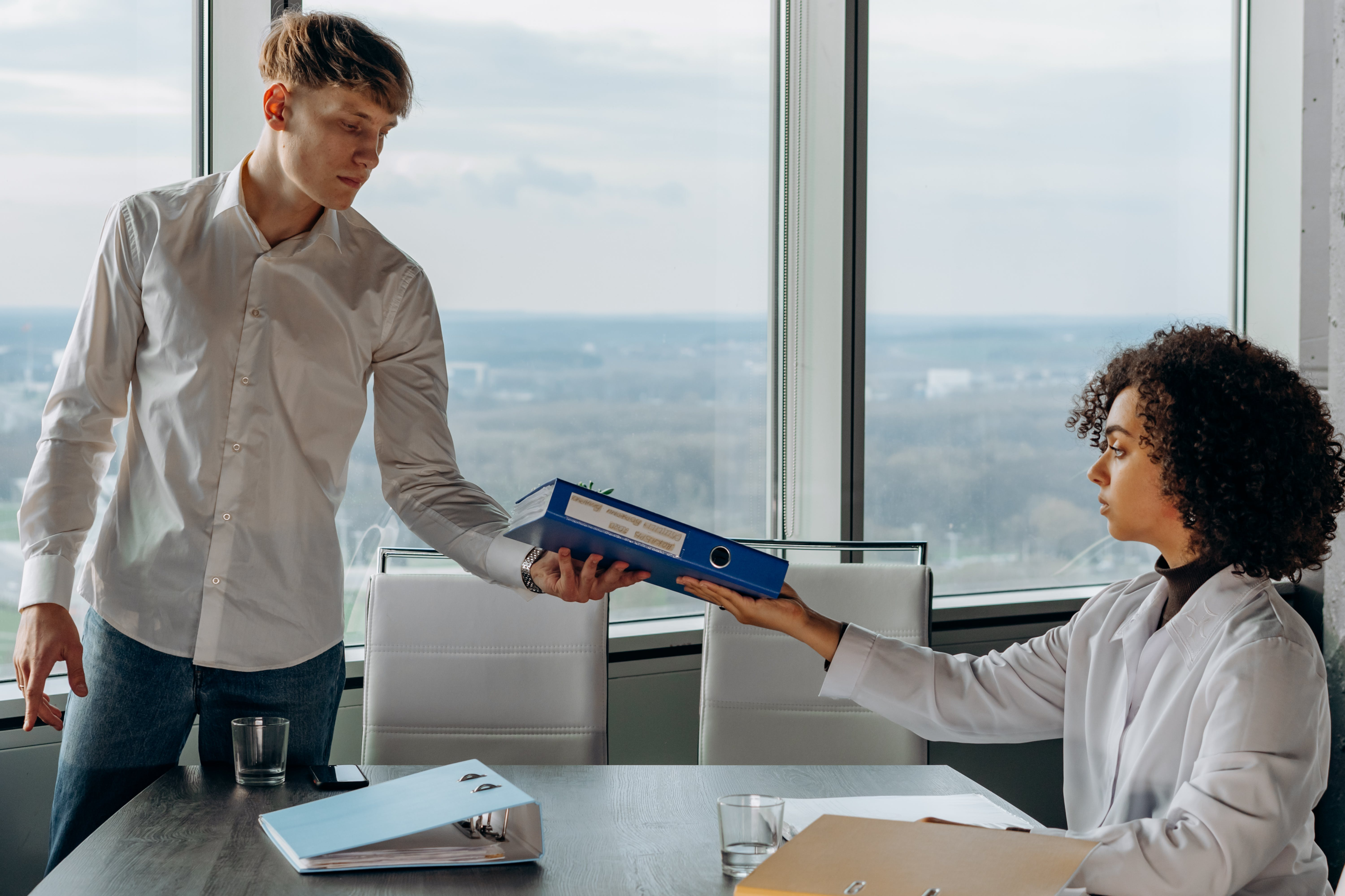 Man Handing Work Book Back to Boss