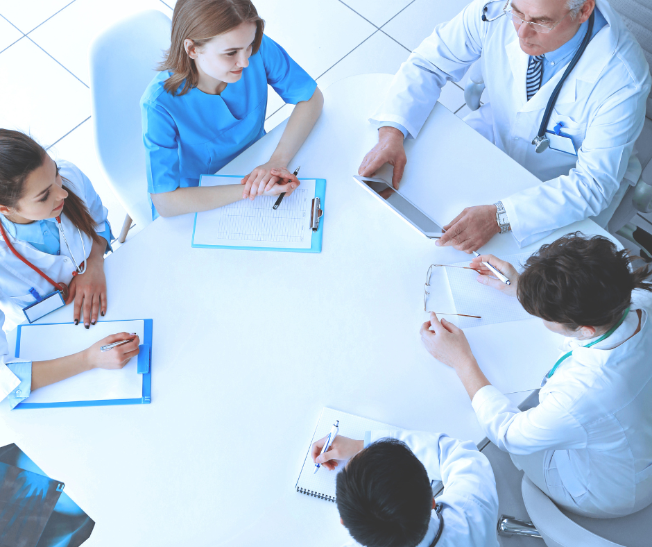A group of healthcare professionals discussing a treatment plan for a patient in a rehab center