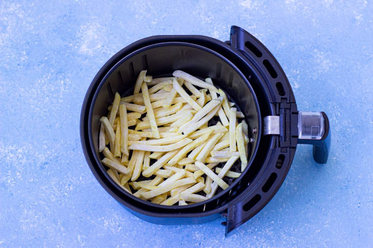 Frozen french fries inside the air fryer.