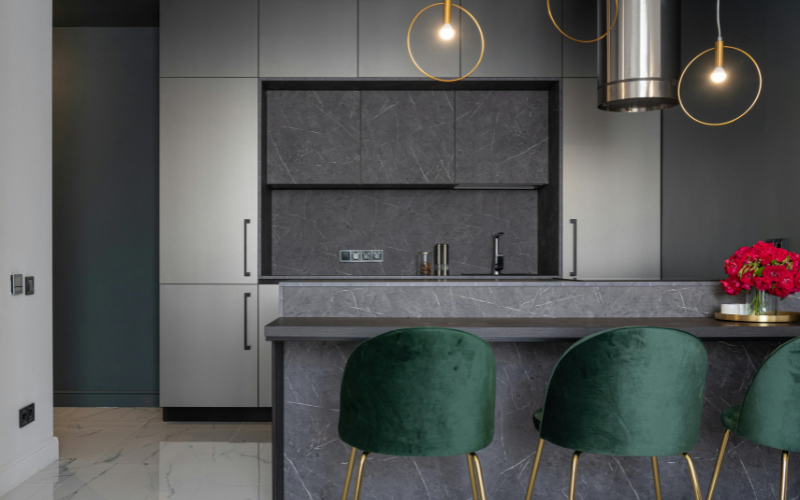 A kitchen with low and dim pendant lights in a well designed kitchen