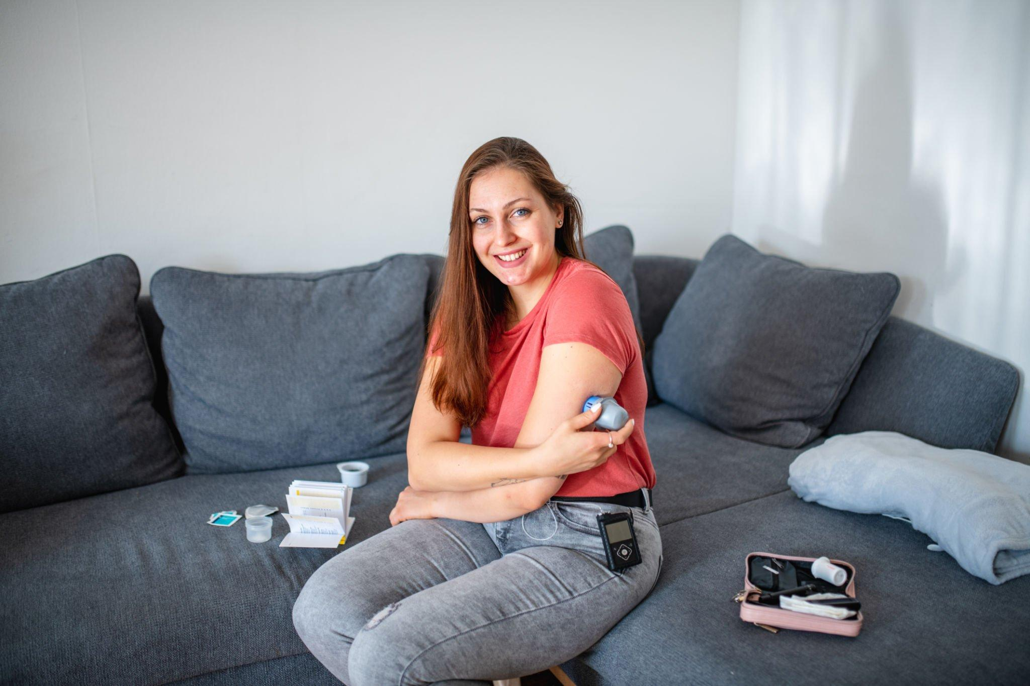 A woman using a CGM device to monitor her blood sugar levels, a valuable tool for managing high blood sugar levels in individuals with diabetes and prediabetes.