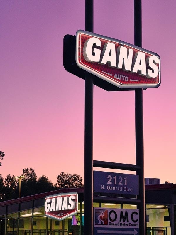 Towering above the street, the Ganas Auto pylon sign reinforces brand visibility from a distance, working seamlessly with the storefront signage for maximum impact.