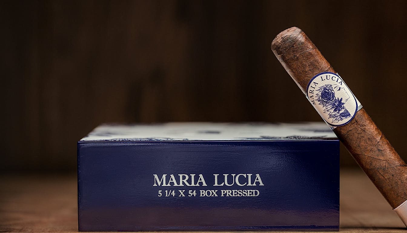 A blurred image of a maria lucia cigar resting on a wooden table.