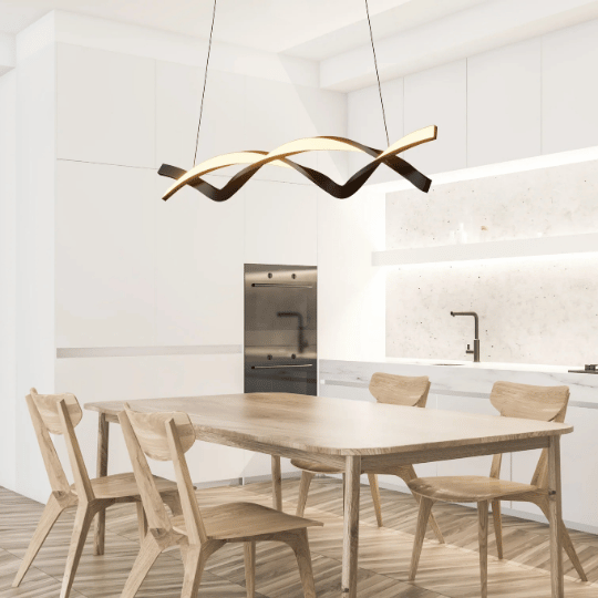 Modern kitchen with wooden dining table and chairs, featuring a sculptural wave-shaped pendant light hanging above the table.