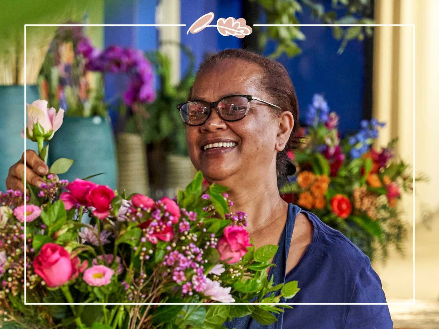 Woman smiling while holding a bouquet of mixed pink flowers - Fabulous Flowers and Gifts