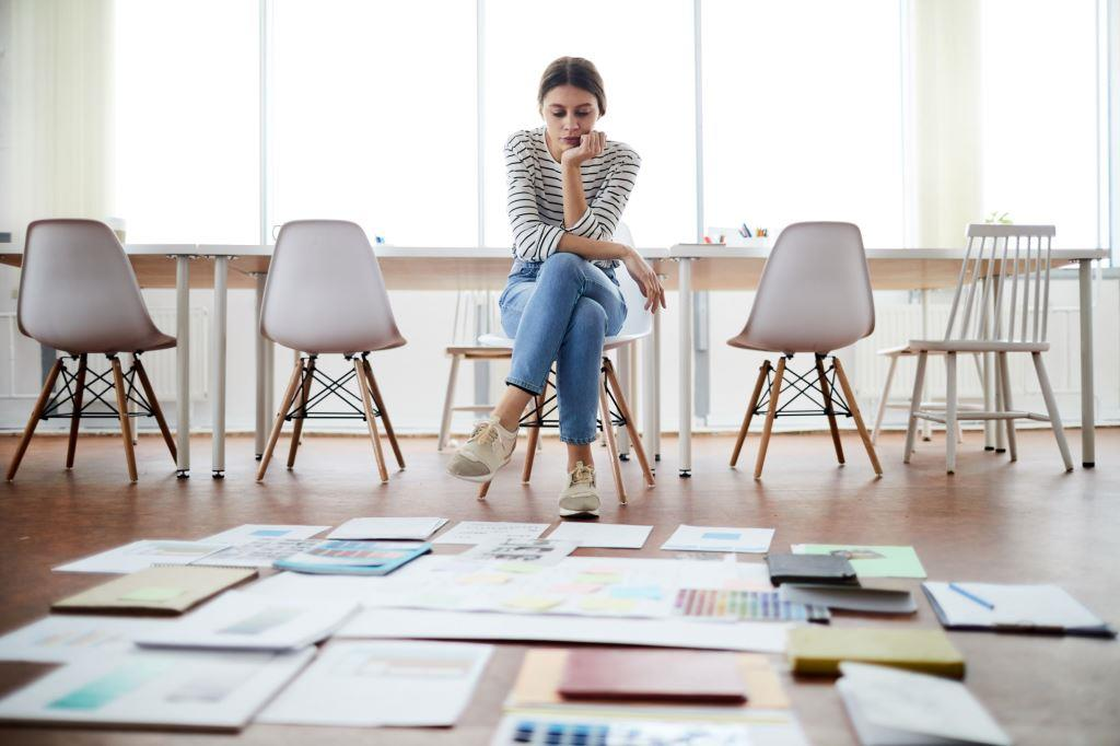 woman looking at a floor with tile colors and styles.