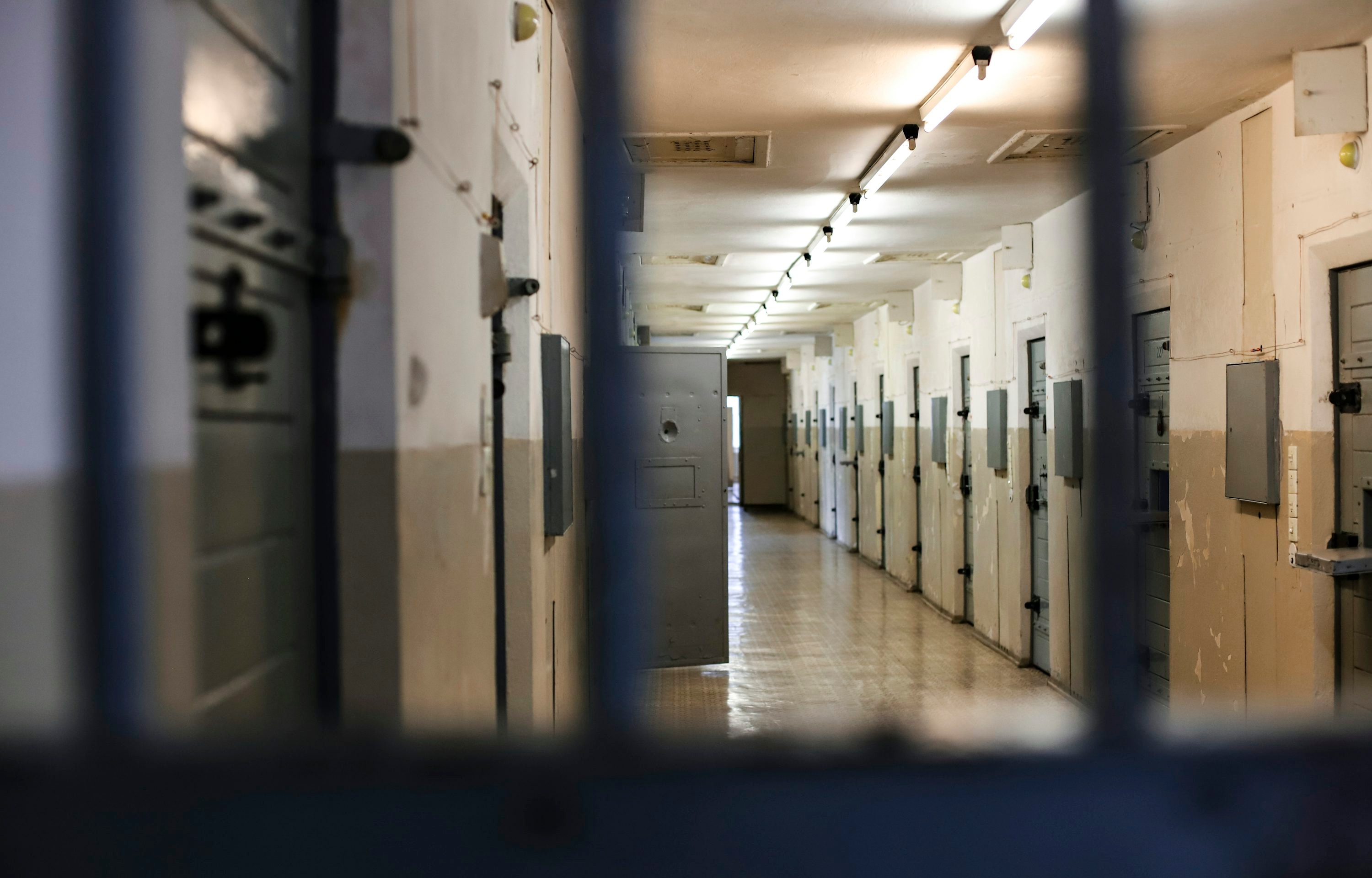 Teardrop Tattoo Meaning: What Does It Mean? 1 Hallway in a prison showing jail cells - Teardrop tattoo meanings and origins in prison life and gang culture.