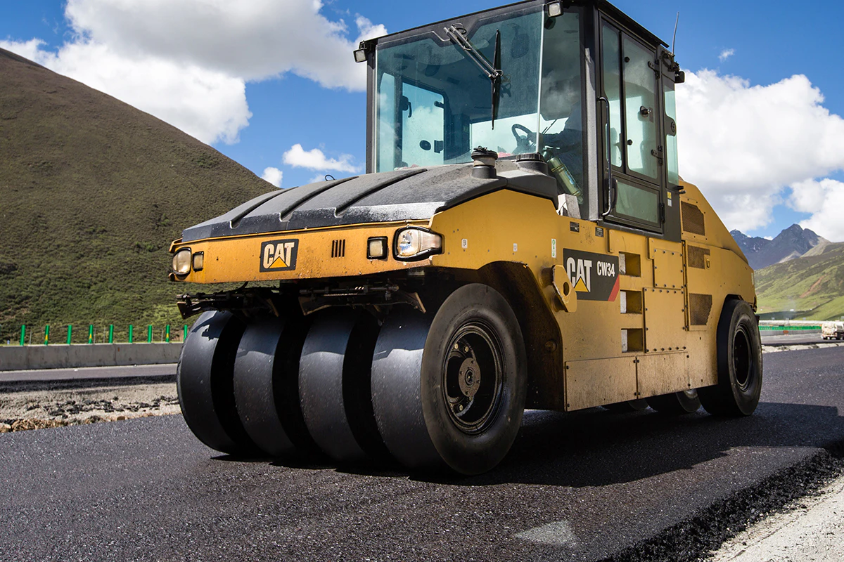 A photo of a pneumatic tire roller and a steel wheeled roller being used to create a smooth surface on an asphalt surface