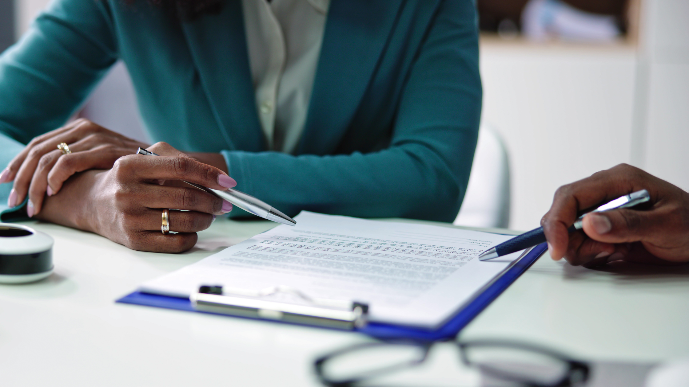Two professionals reviewing a contract on a clipboard, focusing on vendor relationships, existing services, and convergent billing strategies.