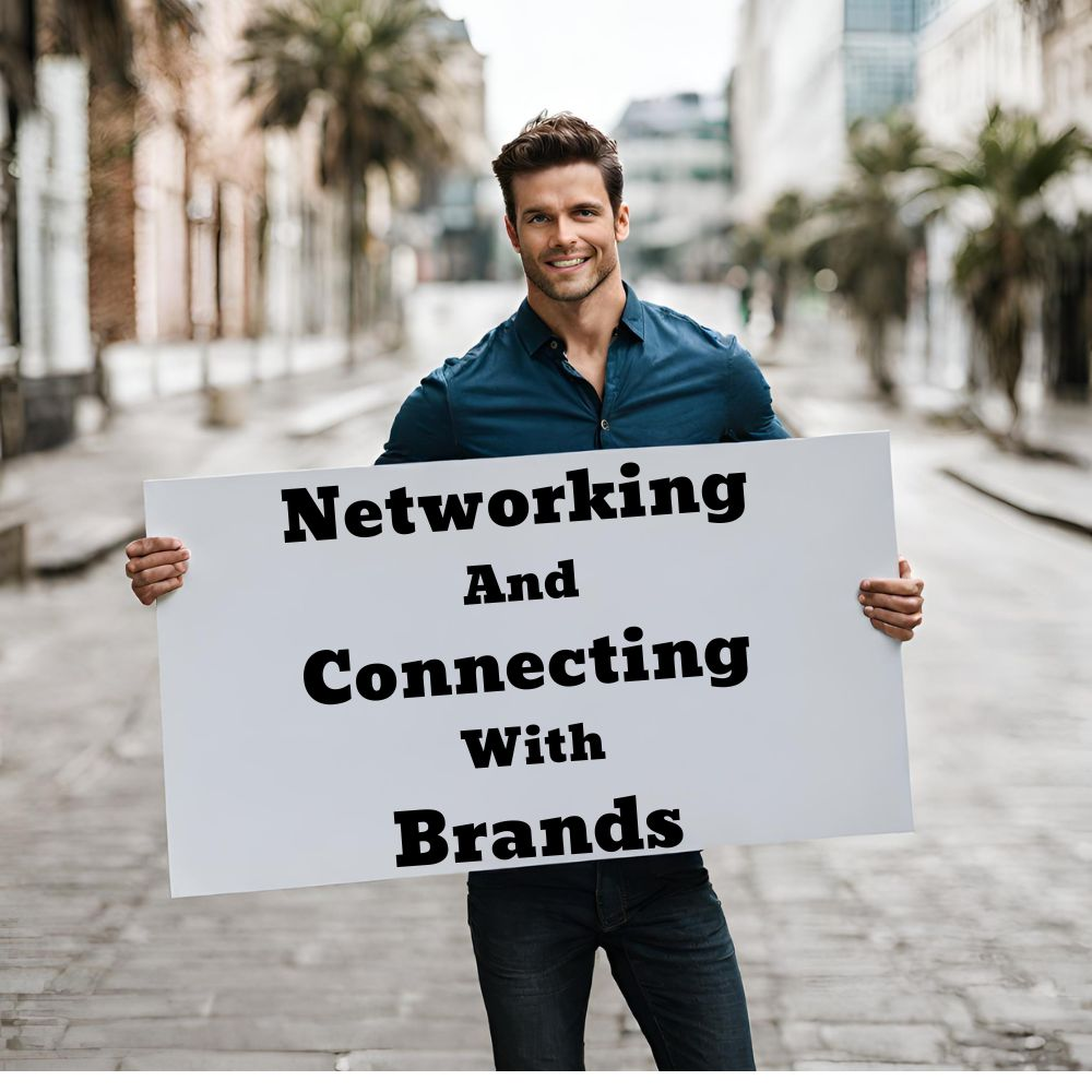 A person smiling while holding a sign with the words "Networking and Connecting with Brands"