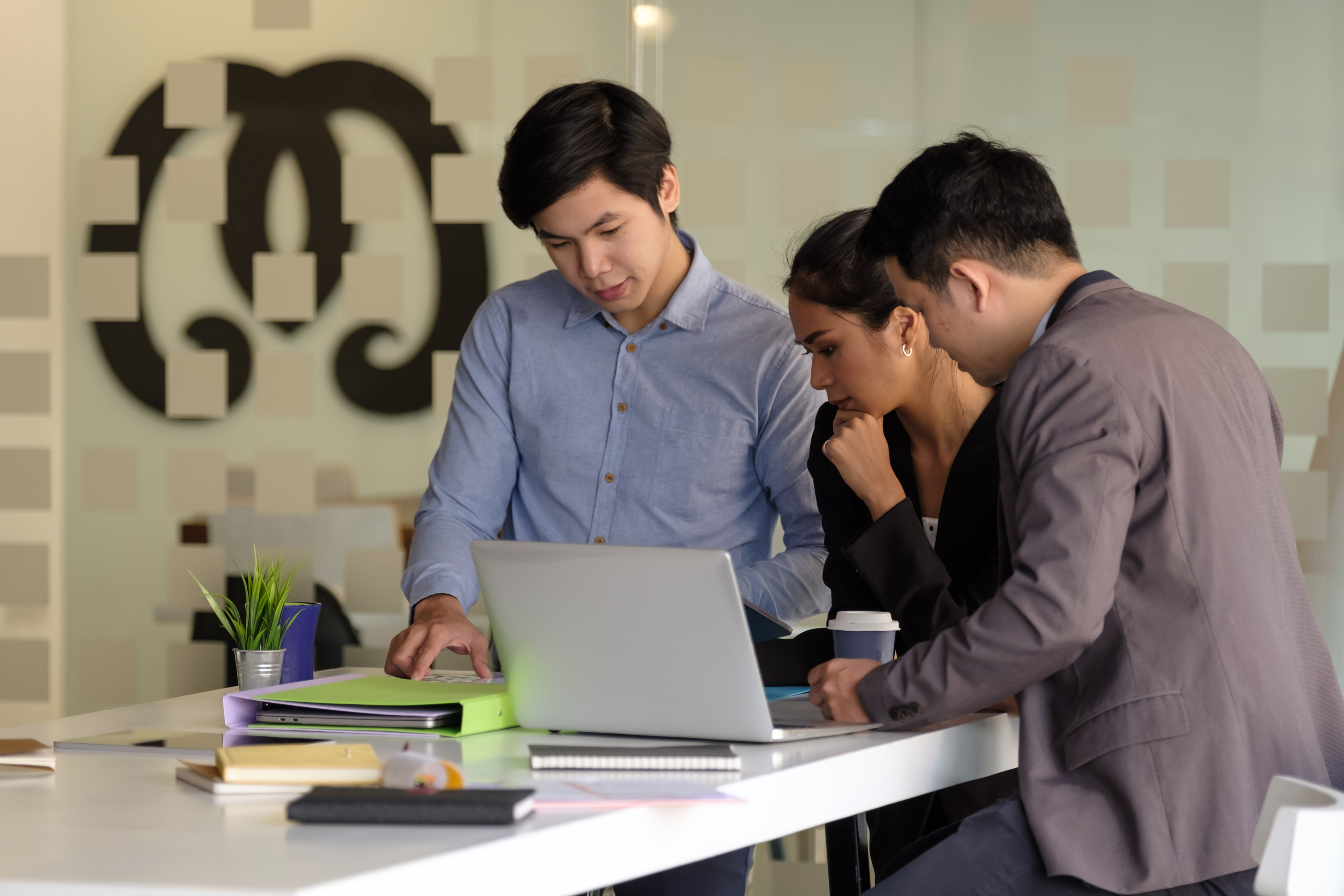 Group of business people analysing data on a laptop