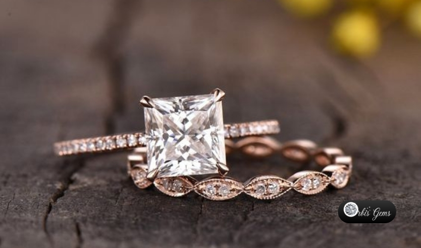 Elegant princess cut diamond engagement ring with pavé band set on a rustic wooden surface, showcasing how to choose the perfect princess cut diamond, by Orbis Gems