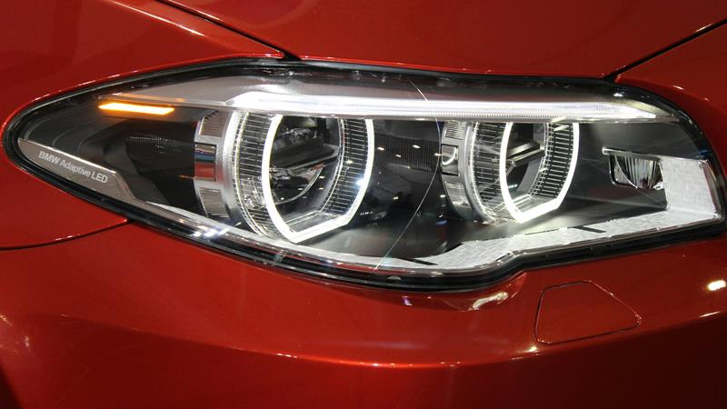 Close up of LED headlights in red car.