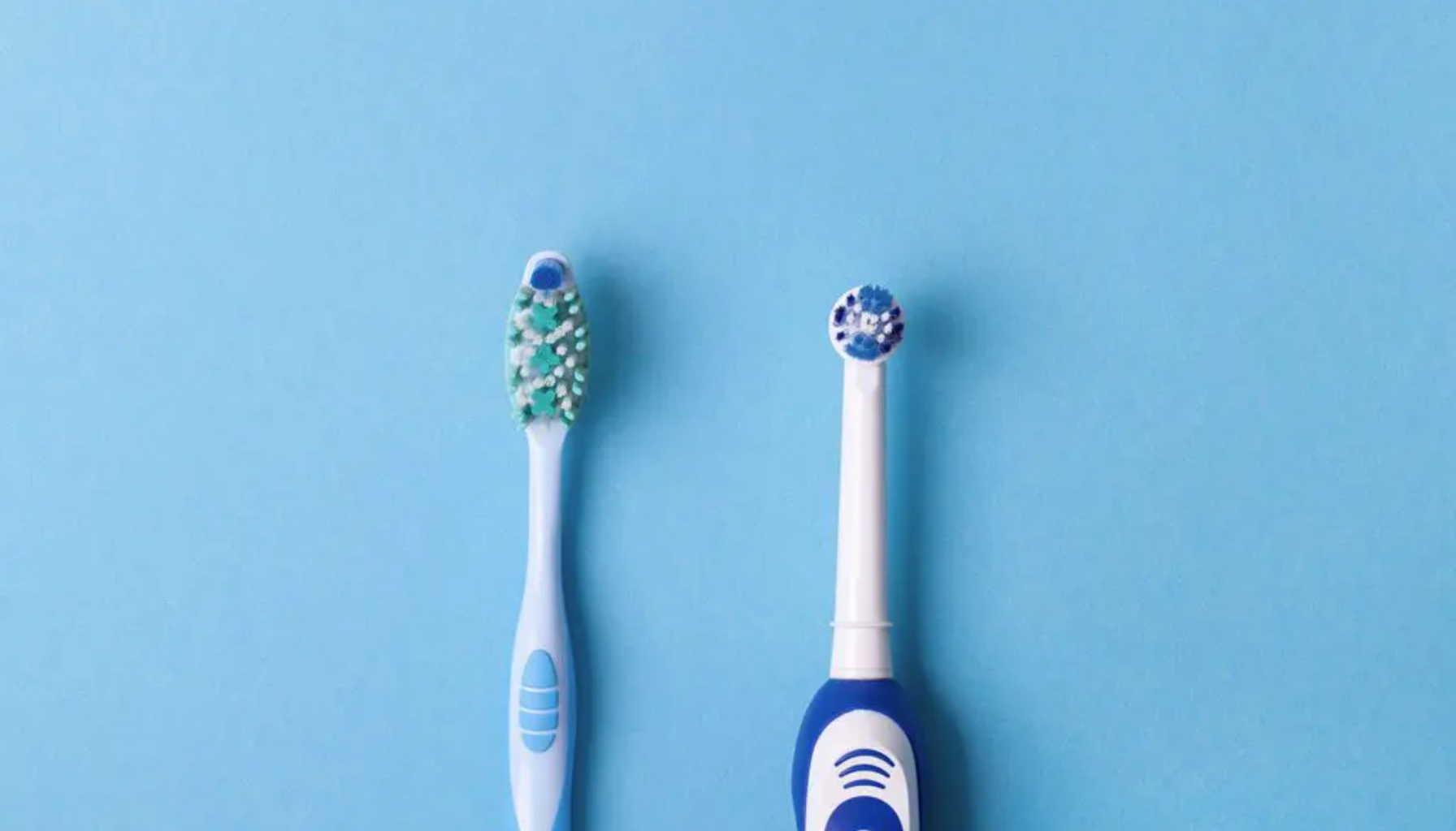 Hvor ofte bør du bytte tannbørste? Ekspertenes anbefaling 14 Manuell og elektrisk tannbørste plassert side om side mot blå bakgrunn, viser forskjell i design og bustform.