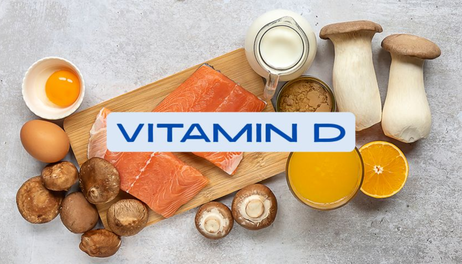 "Matkilder rike på vitamin D, inkludert laks, egg, melk, appelsinjuice og sopp, vist på bord med teksten Vitamin D."