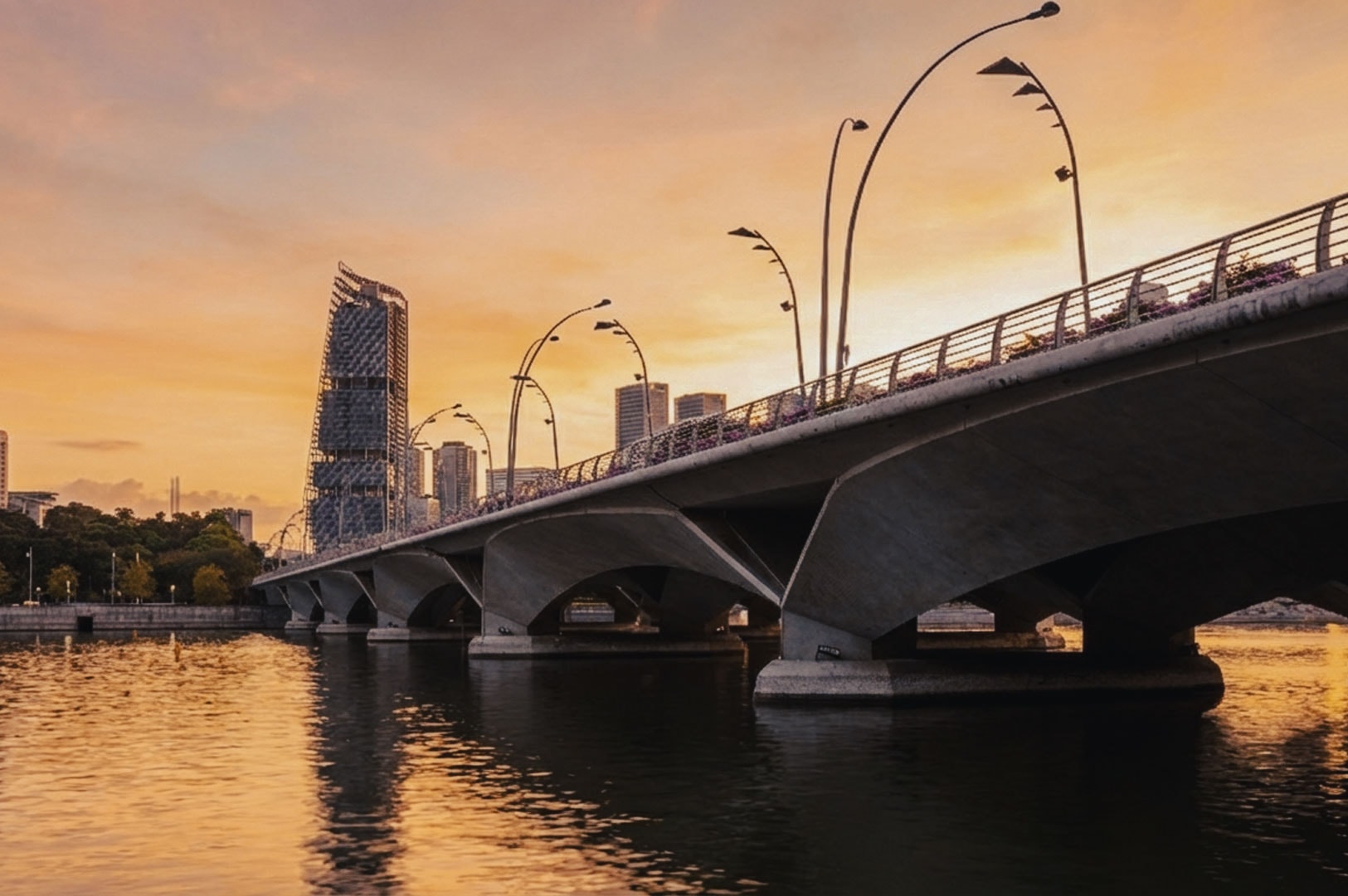 Esplanade Bridge in Singapore illuminated by soft sunset light with the skyline in the distance.