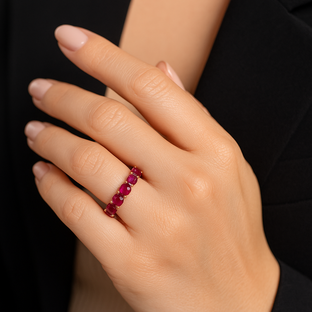 Elegantiškos moters ranka su raudono aukso žiedu juostele, puošta ryškiais raudonais rubinais ir mažais deimantais, sukuriant karališką įvaizdį