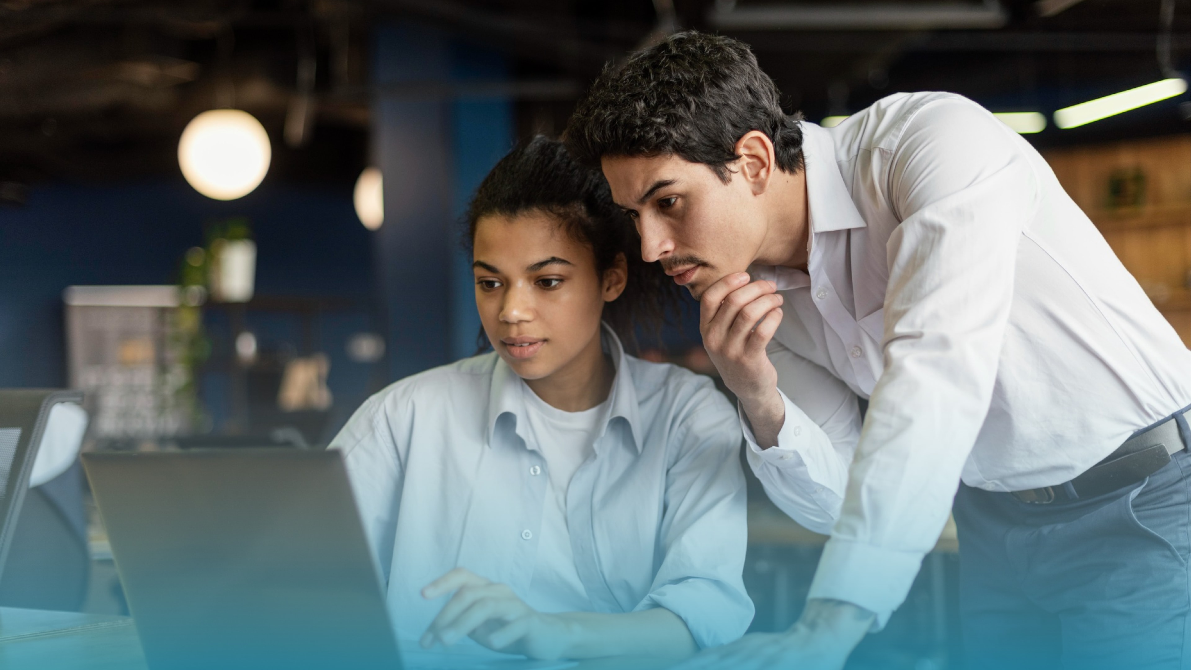 Two colleagues closely examining a laptop screen, highlighting reliable service with high upload speeds from symmetric internet connections.