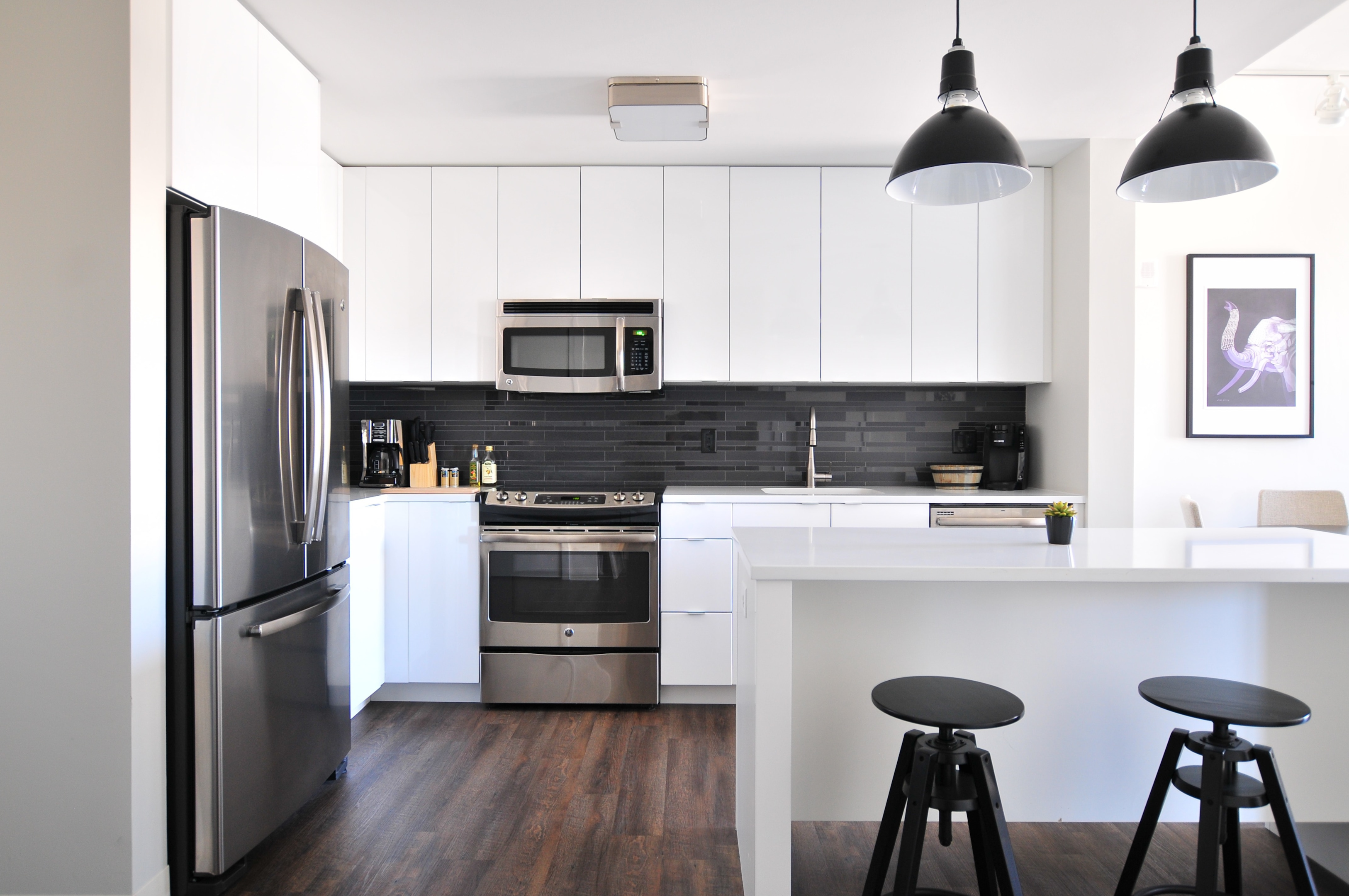 kitchen with white cabinets and black backsplash
