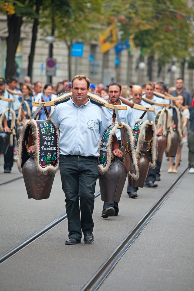 Younger Swiss mandressed formally carring cowbells.
